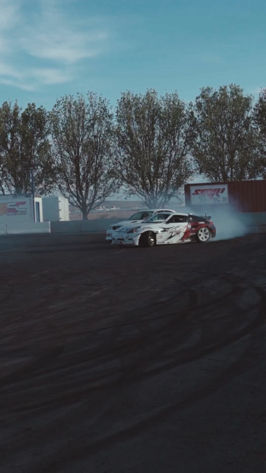 Drift cars in motion at an outdoor automotive event